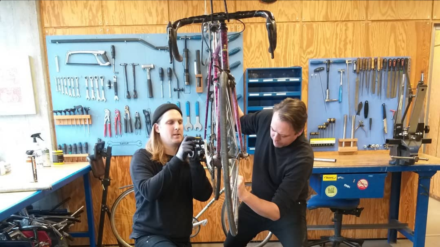 mænd reparerer cykel i cykelværksted på kofoeds skole