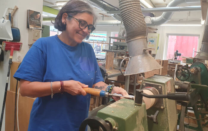 Tyrkisk dame arbejder på drejebænk i fællesskabet på ReDesigns træværksted på Kofoeds SKole